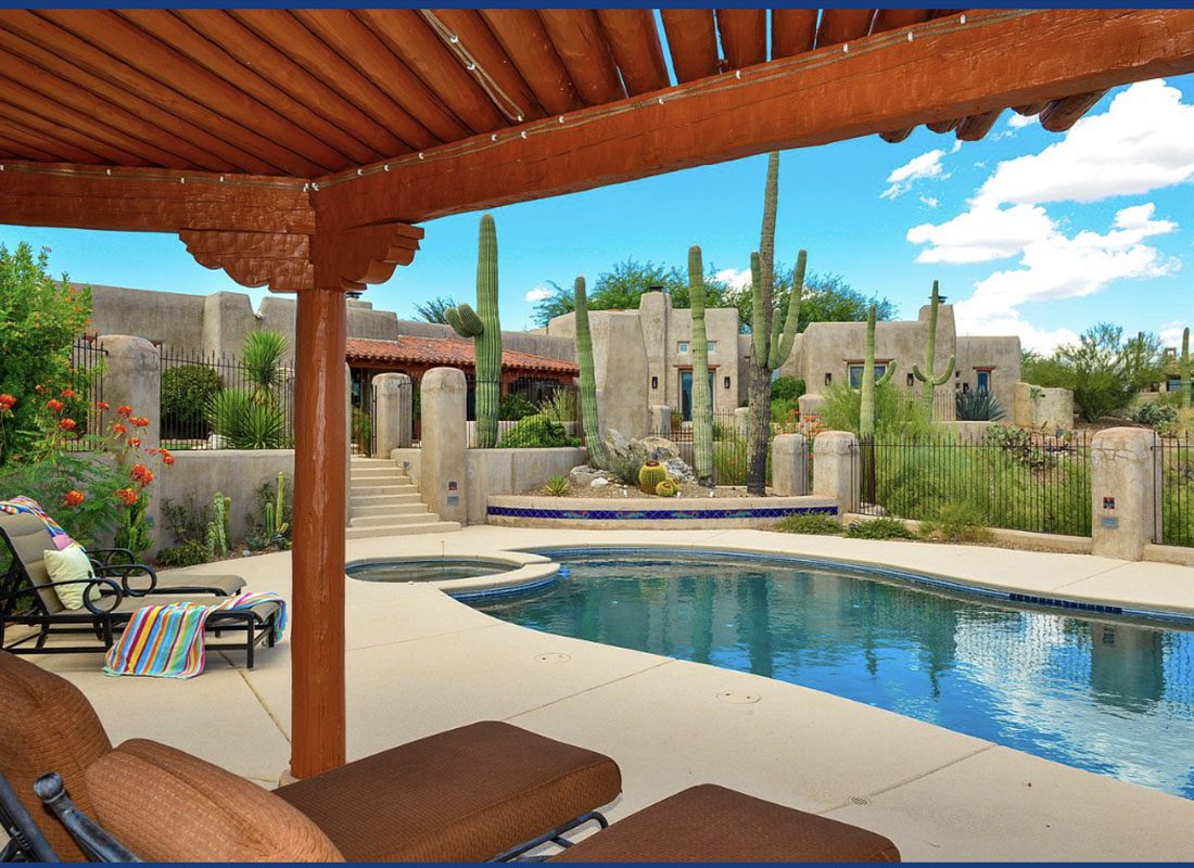 Insurance Solutions - View of a Trellis with Lounge Chairs Next to a Pool with a Nicely Landscaped Yard in a Luxury Home in Arizona